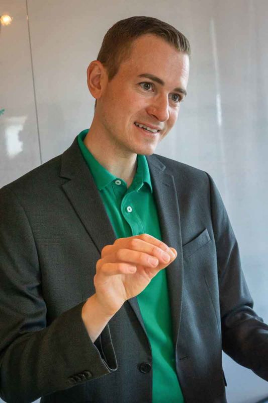Frederik Schafmeister mit Jacket in Beratungsgespräch am erklären